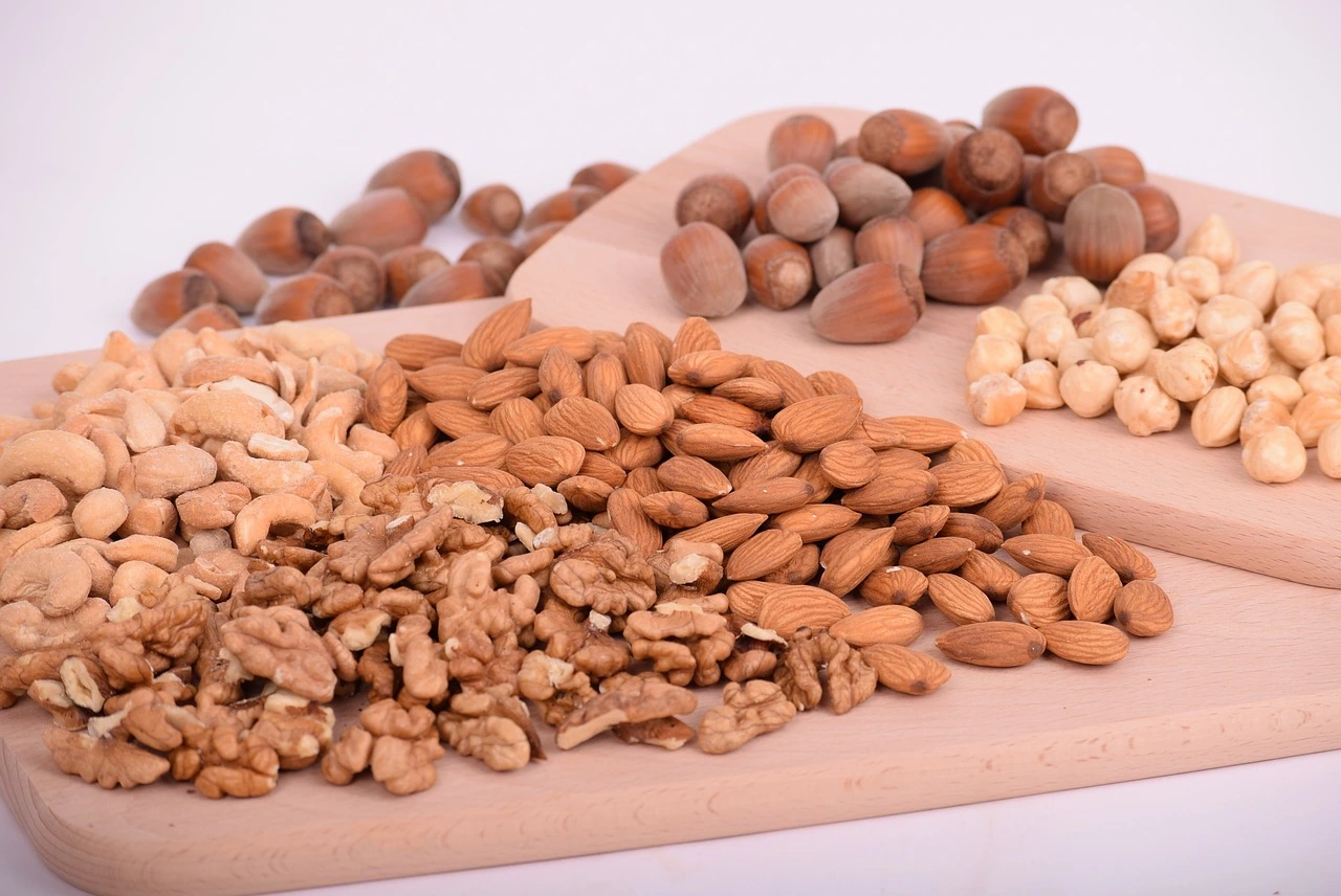  A variety of premium nuts displayed on a wooden cutting board, showcasing their rich textures and colors in Sharjah