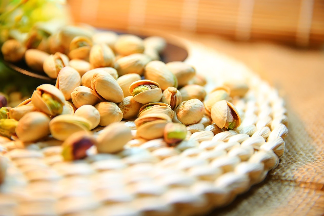 A wicker plate filled with premium pistachios, showcasing their vibrant green color and rich texture in Sharjah