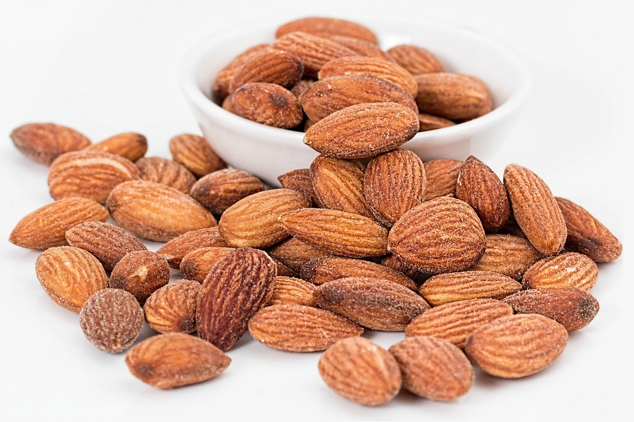 A bowl of premium almonds displayed on a white background, showcasing their quality and freshness from Sharjah